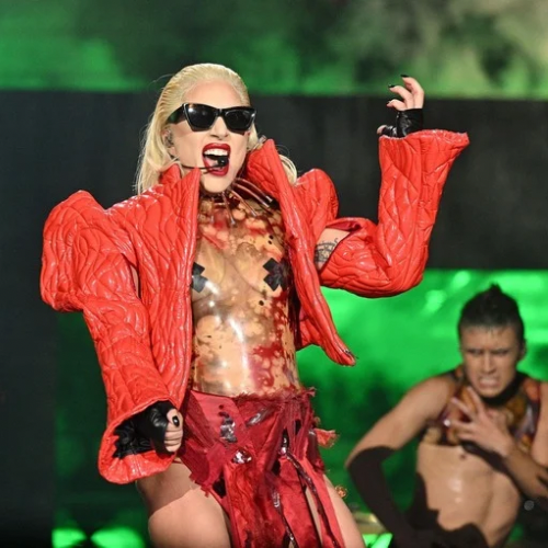 Lady Gaga in a bold red outfit performing on stage